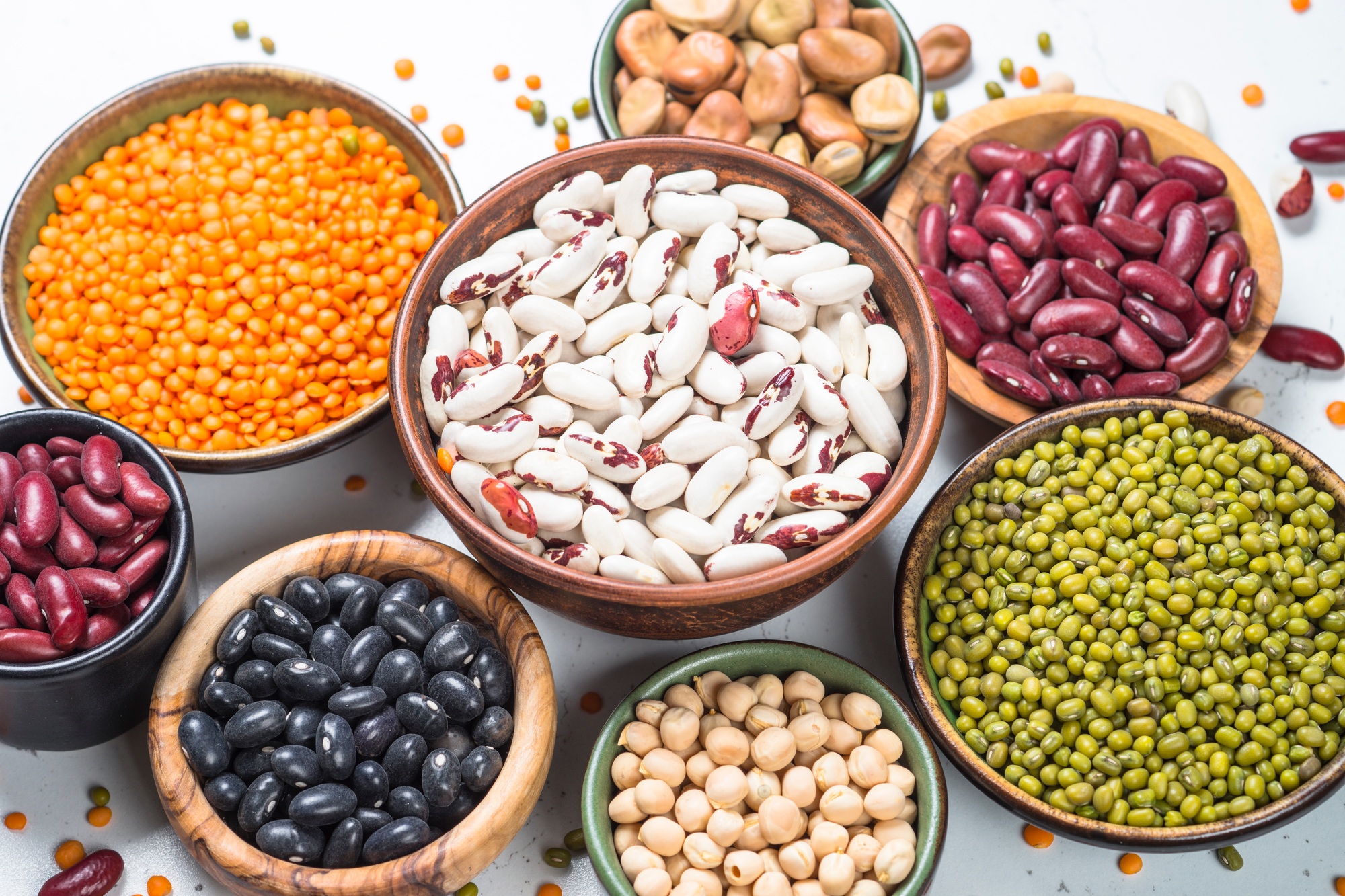 Legumes, lentils, chikpea and beans assortment on white.